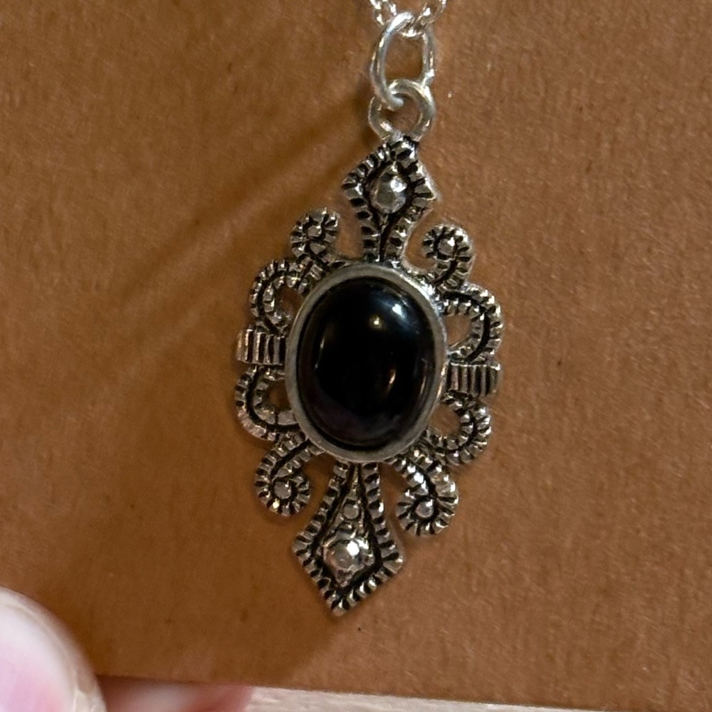 Black and silver tone pendant with stone center & silver tone chain, 18” approx.